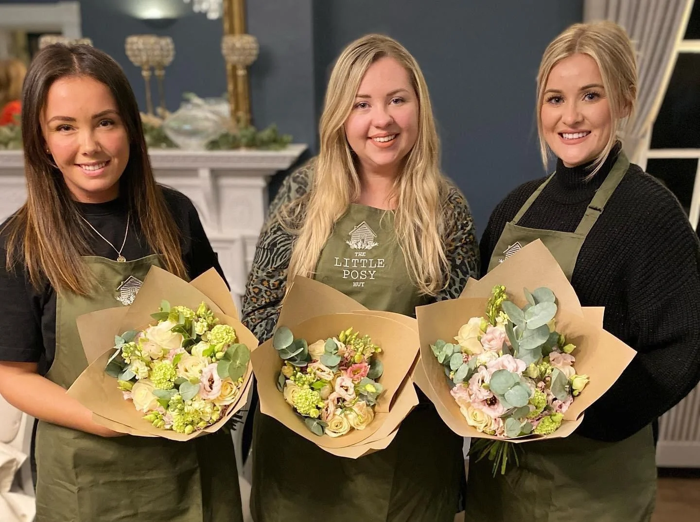 A corporate group enjoying a flower arranging workshop with fresh blooms in a bright indoor space at Downham Hall.