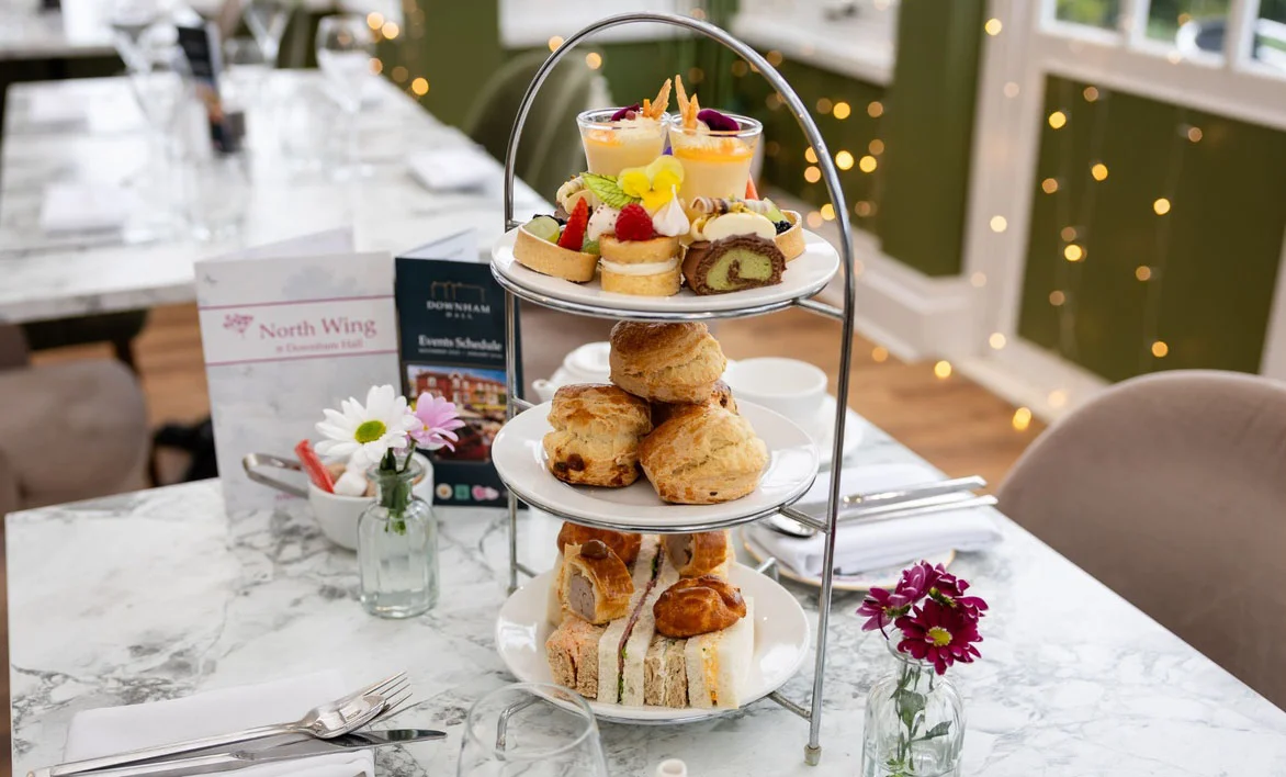 Afternoon tea stand with cakes, sandwiches and scones at Downham Hall Essex