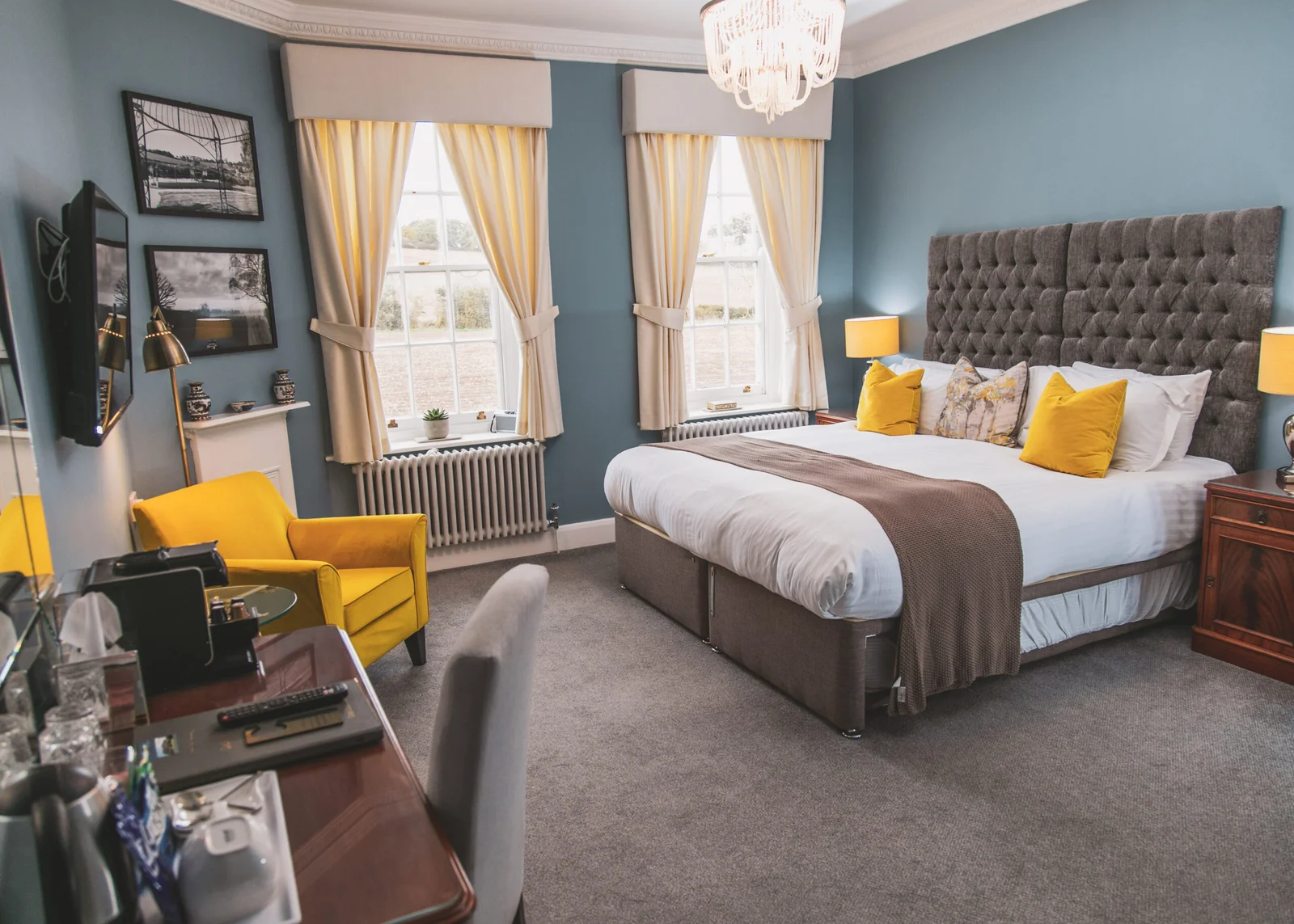 Modern boutique guest bedroom at Downham Hall Essex with double bed yellow chair and elegant decor