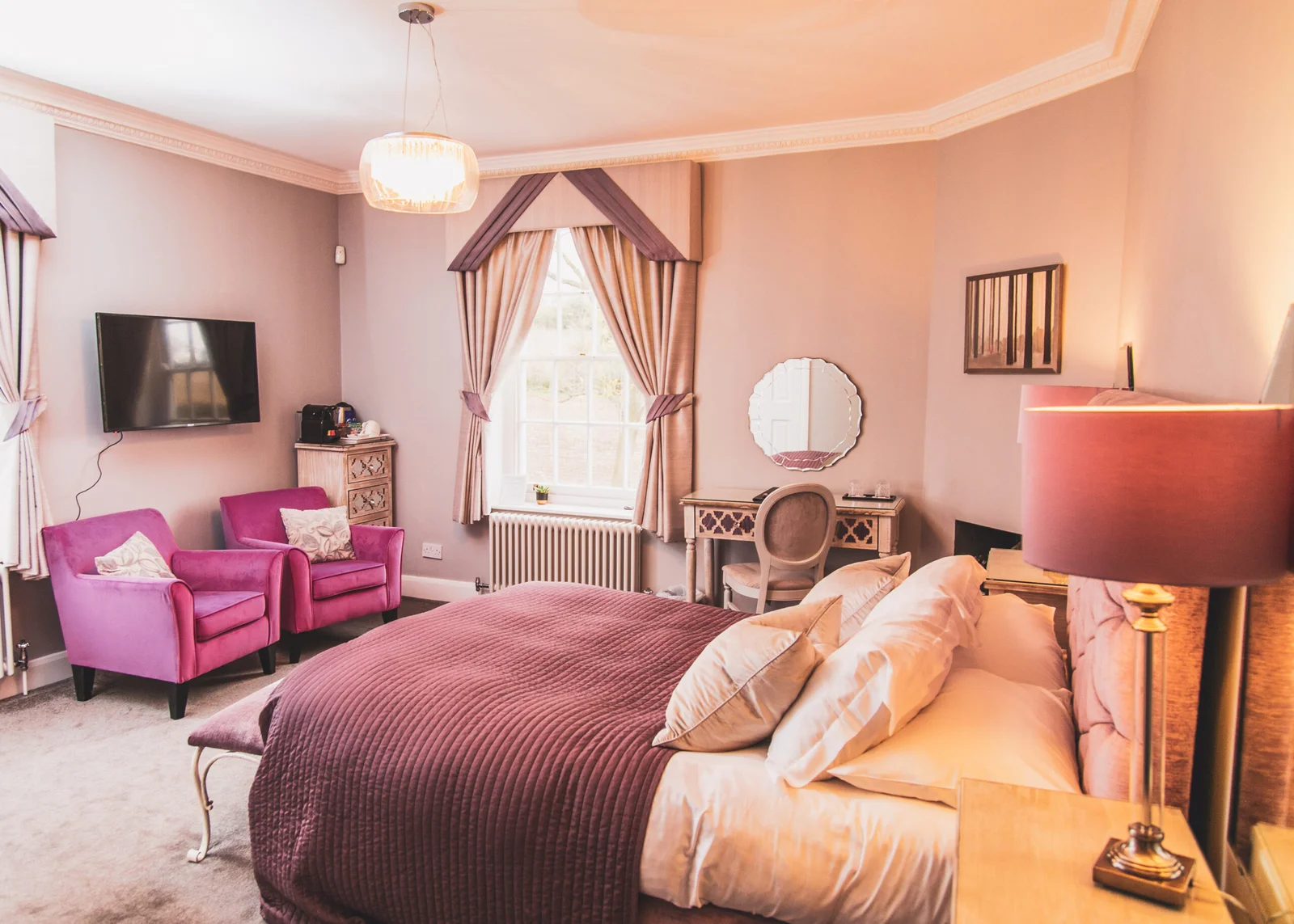 Spacious Gidea guest bedroom at Downham Hall Essex with pink decor seating area and double bed