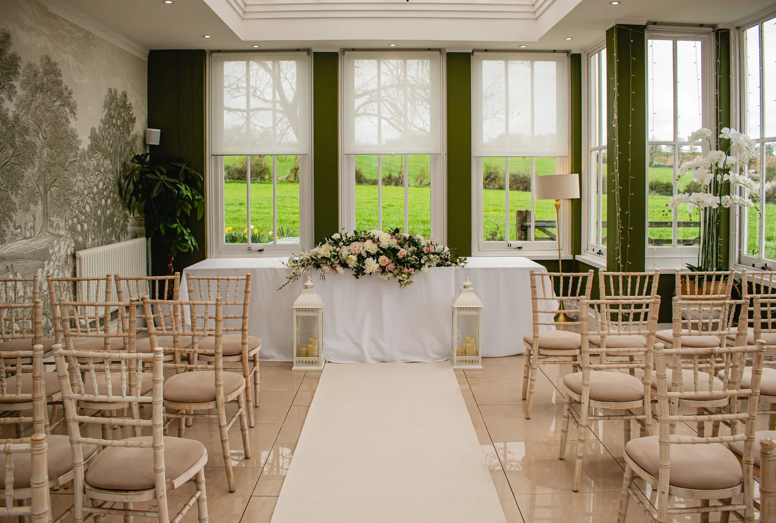 Light-filled orangery wedding ceremony with large windows at Downham Hall Essex