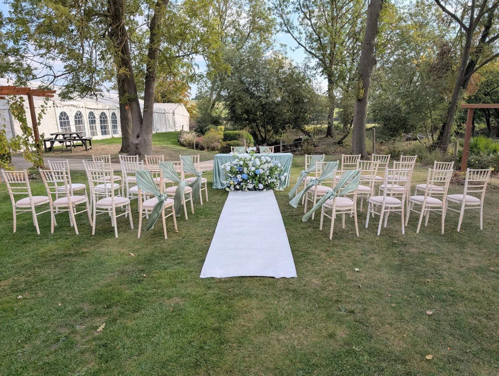 Outdoor garden wedding ceremony setup with chairs and aisle at Downham Hall Essex