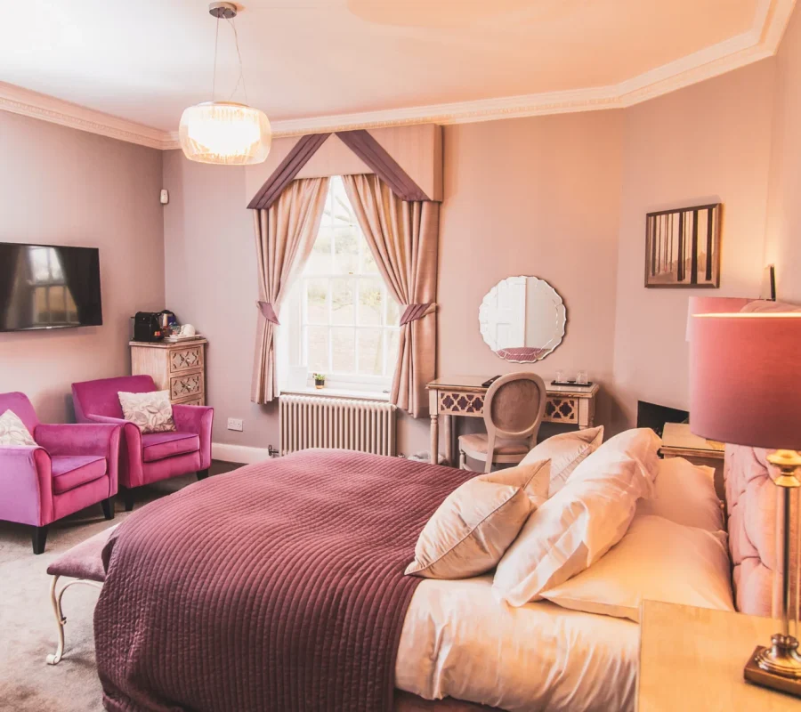 Boutique style wedding accommodation bedroom with soft pink interiors at Downham Hall